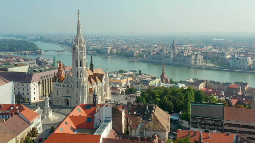Budapest, Hungary - 4K drone flying at Fisherman's Bastion by Matthias Church with clocktower and Parliament of Hungary at background on a sunny summer day Royalty-Free Stock Footage #1036333340