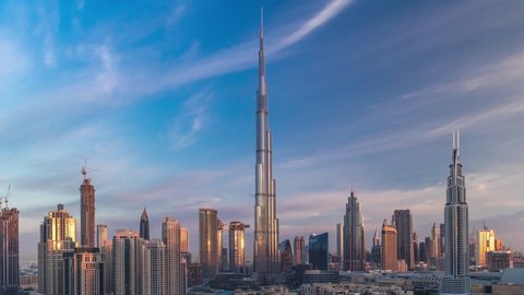 Dubai Downtown skyline timelapse with towers with long shadows during sunrise paniramic view from the top in Dubai, United Arab Emirates. Traffic on circle road and old style buildings