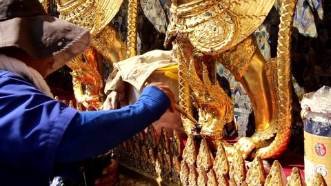 Bangkok , Phra Nakhon / Thailand - 01 06 2018: Worker cleans golden statue, Temple of the Emerald Buddha