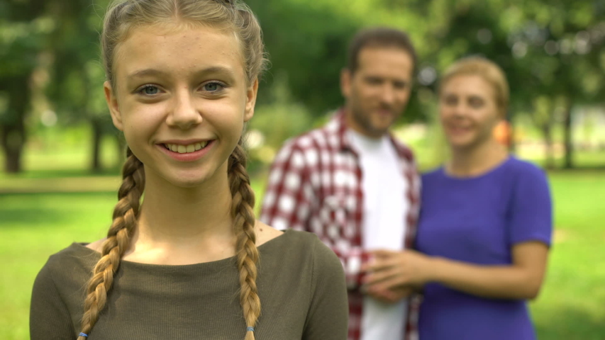 Pretty girl smiling on background of her happy parents, loving and caring family | Shutterstock HD Video #1036350083