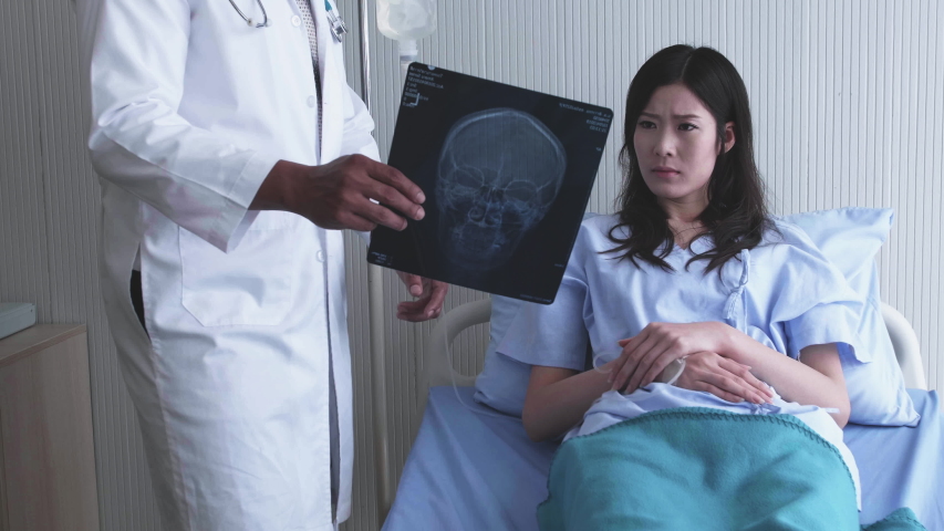 Doctor explained the disease in x-ray film to a patient listener. Bad news and She is have symptoms stressful, headache Royalty-Free Stock Footage #1036351175