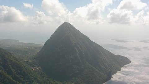 Two people on a Big caribbean Mountain (Petit Piton), drone view fly past revealing another Mountain (grand Piton), High above sealevel, blue ocean from st. lucia,