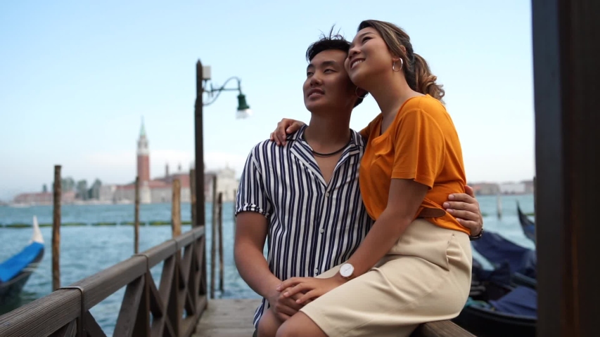 Asian couple in love embraced in Venice in front of the gondolas | Shutterstock HD Video #1036362392