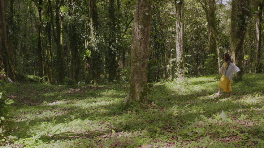 Young woman wondering in serene rainforest, relaxing and enjoying calmness and tranquility