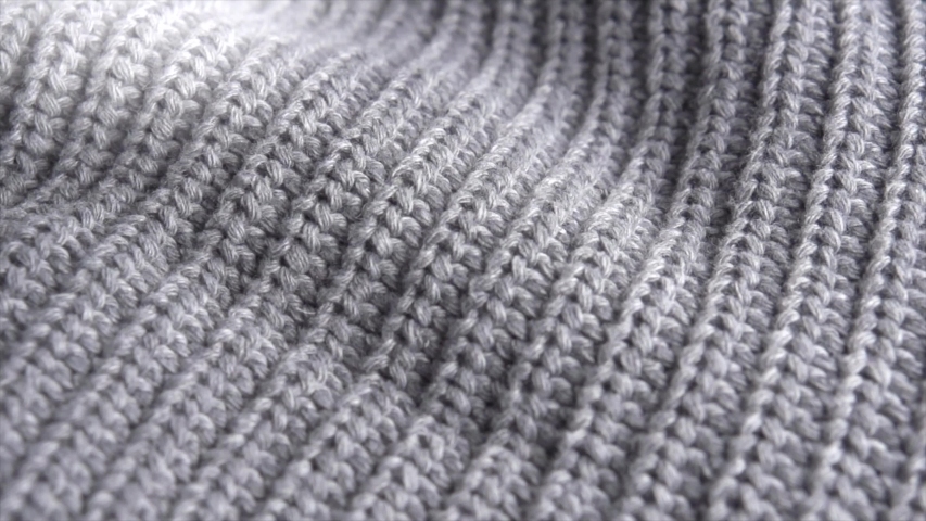 Knitted Wool background. Real Wool clothes texture closeup, dolly shot. Soft grey merino wool macro shoot. Woolen fabric. Knitted texture fabric. 4K UHD video Royalty-Free Stock Footage #1036382444