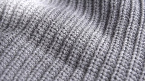 Knitted Wool background. Real Wool clothes texture closeup, dolly shot. Soft grey merino wool macro shoot. Woolen fabric. Knitted texture fabric. 4K UHD video