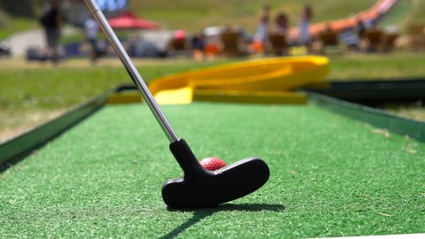 Playing mini golf, cinematic view. Golf ball and Golf Club on Artificial Grass