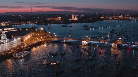 Night aerial view of the water area of the Neva River with many tourist boats near Palace Bridge before opening and waiting show "Singing bridges" in white night in Saint-Petersburg, Russia