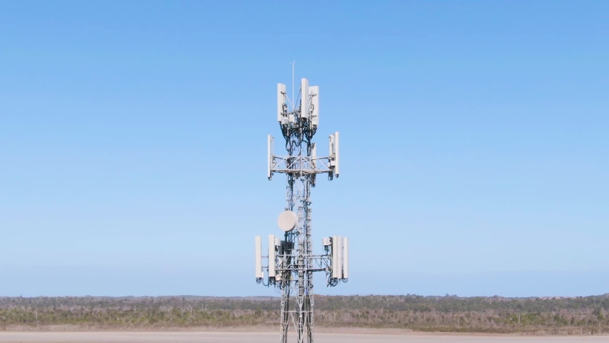 Aerial Orbit: Footage of 5G towers with blue sky background and thin horizon. Rural broadband in country towns. Space for Copy. Royalty-Free Stock Footage #1036389311