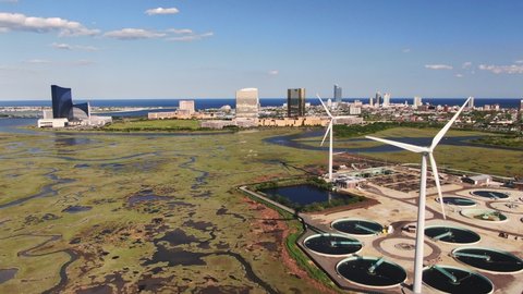 Atlantic City, New Jersey, United States - 06 03 2019: Aerial view of a wind farm, solar plant and wastewater treatment facility on the Jersey Shore, Atlantic City, NJ with casinos in the background