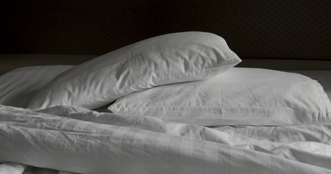 Two pillow and crumpled messy white blanket untidy, Unmade bed after waking up in the morning with a duvet on the bed.