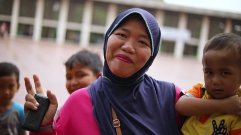 Central Jakarta City , Jakarta / Indonesia - 07 06 2019: Happy Muslim Woman/Mother Waving at the Camera