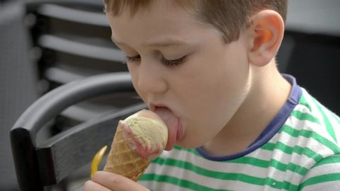 Happy six year old boy eating ice cream