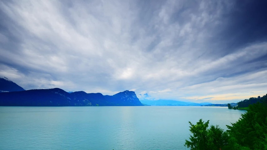Overcast picturesque.Clouds move across the sky above Lake Lucerne and the Alps. Switzerland. Time Laps.