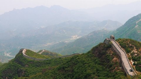 Badaling ancient part of the Chinese wall surrounded by large mountain scenery.