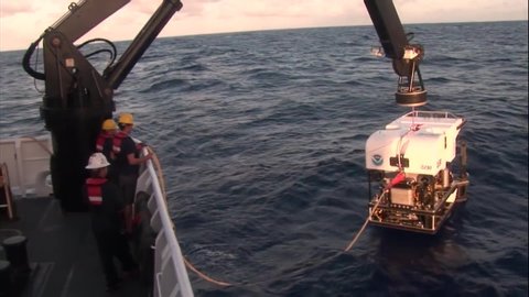 CIRCA 2010s - A deepwater submarine is lowered into the water, shots from the deepwater exploration of the Mariana Trench, 2016