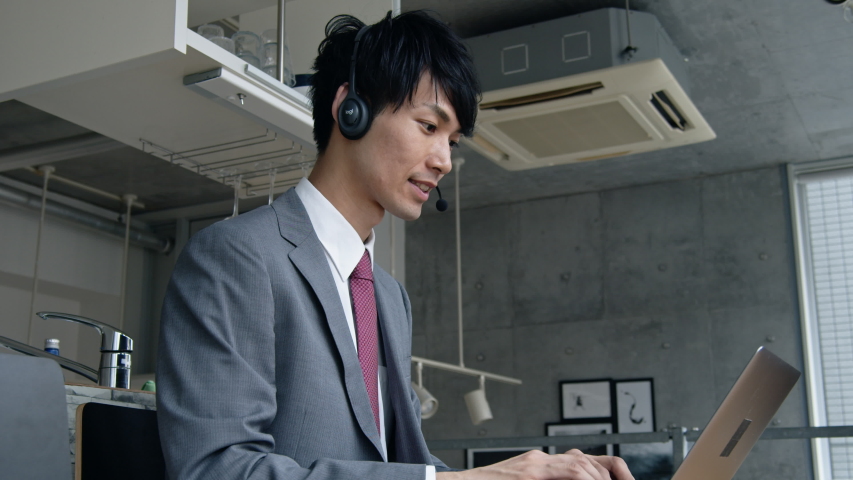 Young asian businessman talking with headset. Teleconference. Telemeeting. E-learning. Royalty-Free Stock Footage #1036432616