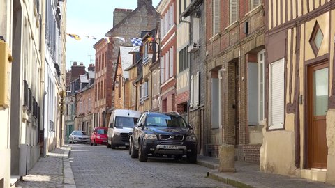 HONFLEUR, FRANCE - CIRCA 2018 - Old cobblestone street and traditional stone buildings in the pretty town village of Honfleur, France.