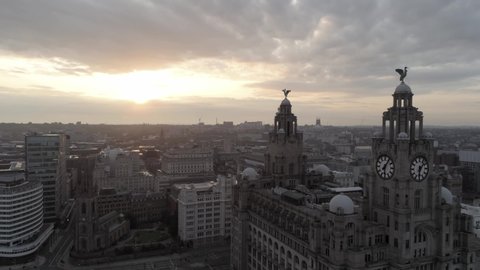 Liverpool / United Kingdom (UK) - 08 04 2019: Sunrise over Liverpool liver building, Liverpool skyline radio tower & cathedrals along the horizon. Aerial orbit left view.