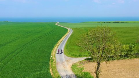 NORMANDY, FRANCE - CIRCA 2018 - Beautiful aerial of a French couple riding bicycles through the green countryside of Normandy, France.