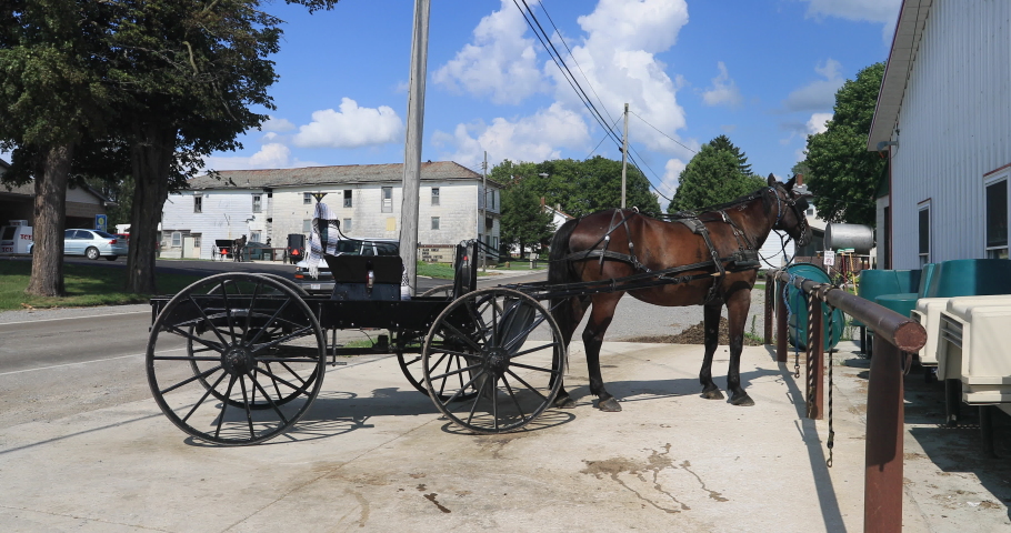 WILMINGTON, PENNSYLVANIA - 11 AUG 2019: Amish community Ohio horse and carriage parked at store. Old Amish Mennonite settlement. Rural old order. Farming landscape and business.