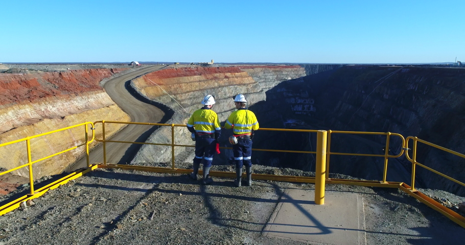Fly over workers looking over mining pit Royalty-Free Stock Footage #1036444982
