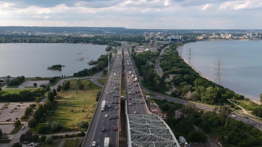 Aerial view of Burlington Bay James N. Allan Skyway arch bridge and QEW highway. Drone dolly shot. Sunny summer day. Hamilton Bay waterfront, Ontario, Canada.
