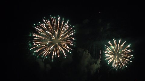 White streaks of light burst into colorful fireworks.