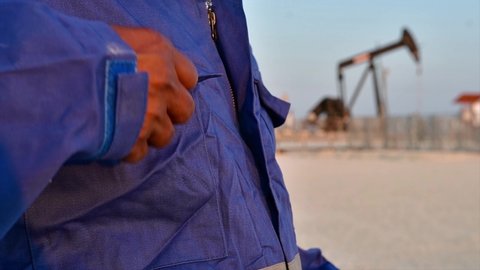 A oilfield technical worker using the H2S gas monitor in the oilfield  at job site - slow motion 
