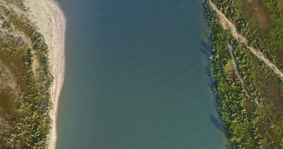Aerial View of Danube River Mouth Flowing into the Black Sea, Sfantu Gheorghe, Romania, sunny summer day
 Royalty-Free Stock Footage #1036449491