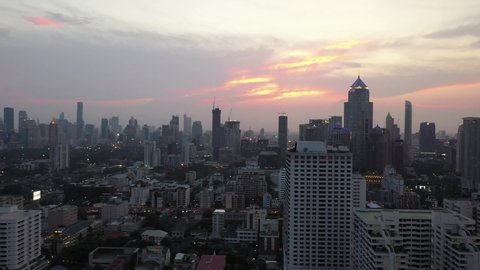 The aerial view of the sunset in Bangkok, the city center, showing dense buildings at sunset, collection of colored sky, evening sky atop the view from 4k video drones