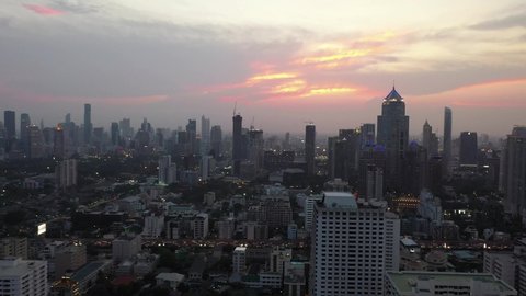 The aerial view of the sunset in Bangkok, the city center, showing dense buildings at sunset, collection of colored sky, evening sky atop the view from 4k video drones