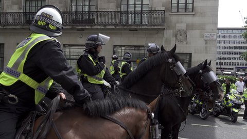 London, United Kingdom (UK) - 08 03 2019: Police officers in riot helmets on top of horses stand in a line