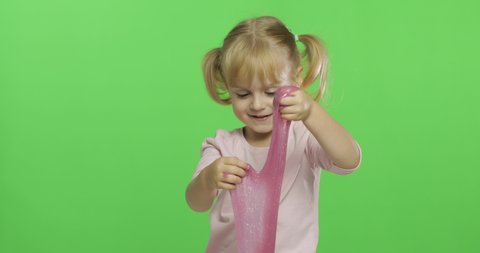 Child having fun making ping slime. Kid playing with hand made toy slime. Funny kid girl. Relax and Satisfaction. Oddly satisfying pink slime for pure fun and stress relief. Green screen. Chroma Key