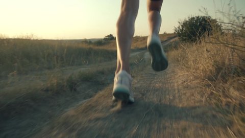 Runner Man Fit Athlete Legs Jogging On Trail Prepares To Triathlon.Triathlete Running,Sprinting And Workout Endurance Training.Running Man In Uphill At Sunset Slow Motion.Runner Marathon Jog On Trail.