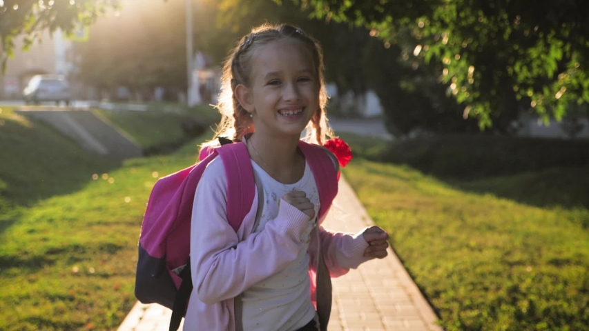 Teenage girl with backpack in sun rays. Happy smiling teen with braided hair go to school in flare sunshine. Concept of back to school and education.