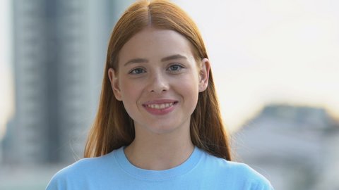 Happy caucasian red-haired girl sincerely smiling on camera, wellness and beauty