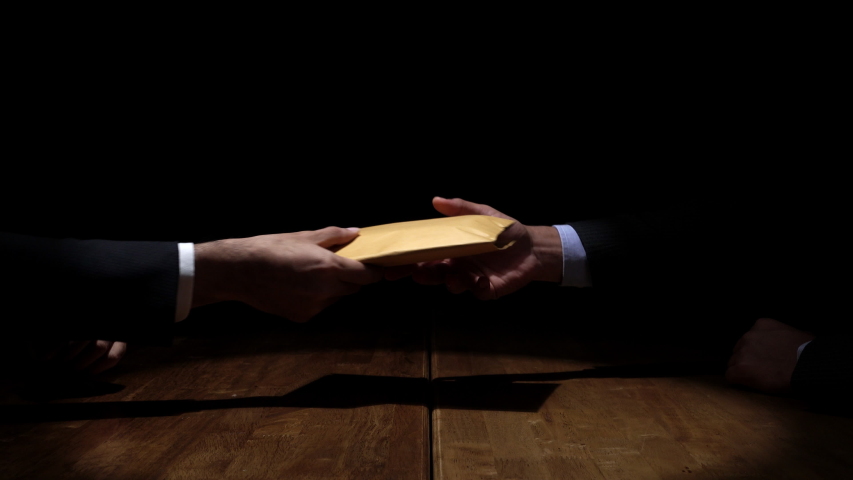 Businessman giving bribe money in brown envelope to partner in dark room for corruption and and bribery concepts | Shutterstock HD Video #1036481894