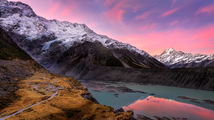 Dramatic sunset at Kea point in Mount Cook national park with pink clouds moving against a blue sky with Mount Cook in the Distance