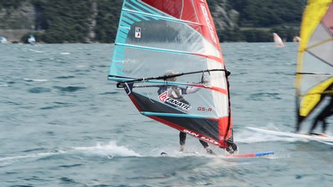 Torbole - Nago, Lago di Garda (Lago Benaco), Italy - July 18, 2019: A windsurfing on Lake Garda in Torbole resort. Windsurfer Surfing The Wind On Waves, Recreational Water Sports