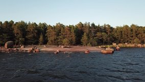 4K summer late afternoon aerial video of Santalahti Baltic Sea Finnish Bay lagoon, pine tree forest beach with red granite boulders, lone island near Kotka, Finland Suomi, northern Europe