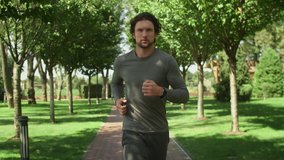 Attractive man, guy jogging in the park on a background of trees, fitness watch - Powered by Shutterstock - Get 15% off with code: PIKWIZARD15