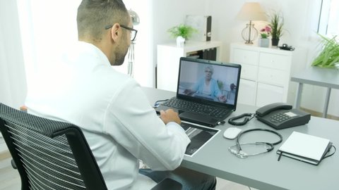 handsome doctor giving remote medical consultation with senior woman patient over internet computer telemedecine diagnostic 