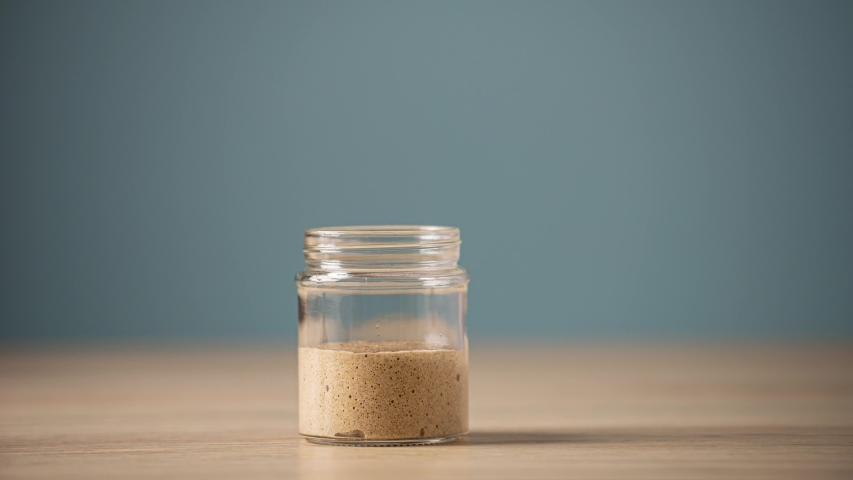 Home made spelt starter yeast rising and fermenting in a glass jar. | Shutterstock HD Video #1036506572