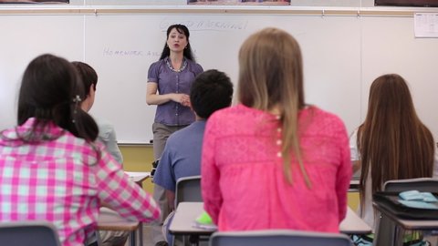 Teacher dismissing junior high students in classroom