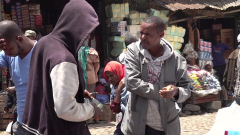 ADDIS ABABA, ETHIOPIA – MARCH 2019: Slow motion of street vendor counting money while talking to customer on Mercato market in Addis Ababa, Ethiopia