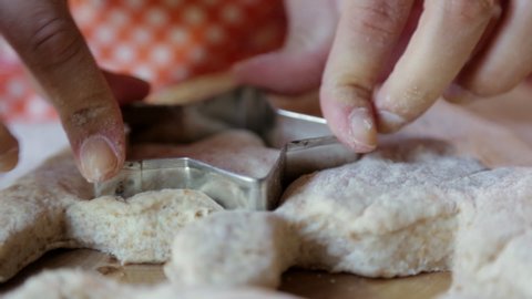 Hispanic woman pressing star shapes in dough