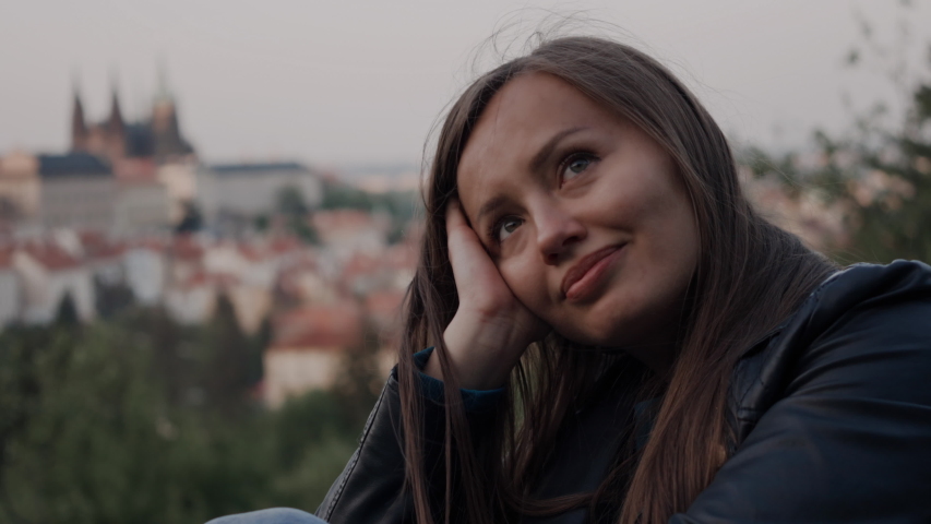 sweet girl sits thoughtfully on top, wind waves her hair and she smiles sometimes. In the background