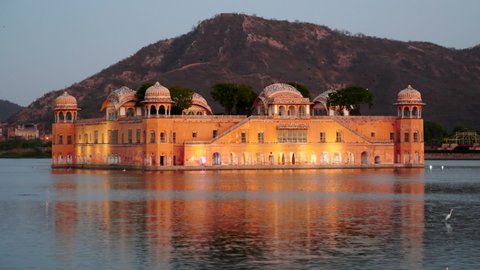 evening close up of jal mahal palace illuminated by lights in jaipur, india