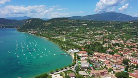 Aerial video with drone. Beautiful coastline. In the city of Bardolino, Lake Garda is the north of Italy. View by Drone. Docked yachts parking in Port.
